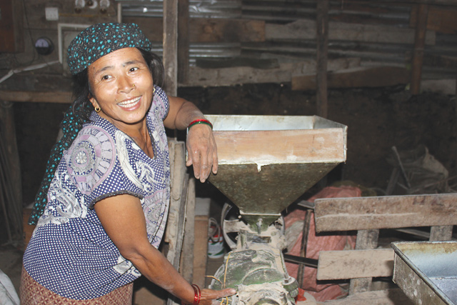 Gami Ghale runs a rice huller, a flour mill and an oil extractor from her shed, a temporary structure made of green corrugated tin sheets.