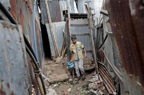 In this June 1, 2016 photo, a Bangladeshi boy walks out from a toilet at a slum in Dhaka, Bangladesh. Through a dogged campaign to build toilets and educate Bangladeshis about the dangers of open defecation, the densely populated South Asian nation has managed to reduce the number of people who defecate in the open to just 1 percent of the 166 million population, according to the government, down from 43 percent in 2003.