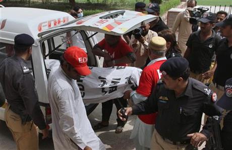 Pakistani police officers stand beside volunteers unloading the dead body of fashion model Qandeel Baloch upon arrival at a local hospital in Multan, Pakistan, July 16, 2016. Baloch, who recently stirred controversy by posting pictures of herself with a Muslim cleric on social media, was strangled to death by her brother, police said Saturday, July 16, 2016.