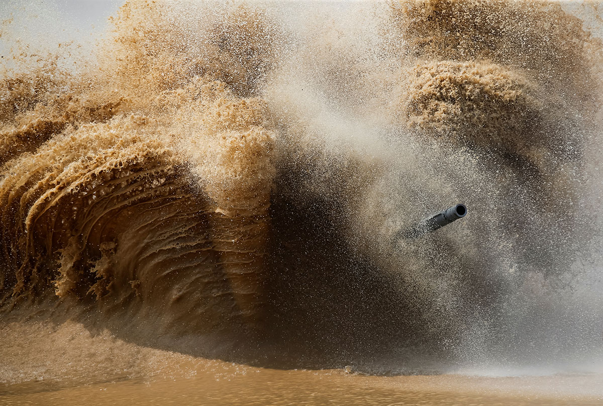 A tank's barrel is seen through the spray on the course of the Tank Biathlon competition in Alabino, outside of Moscow. 