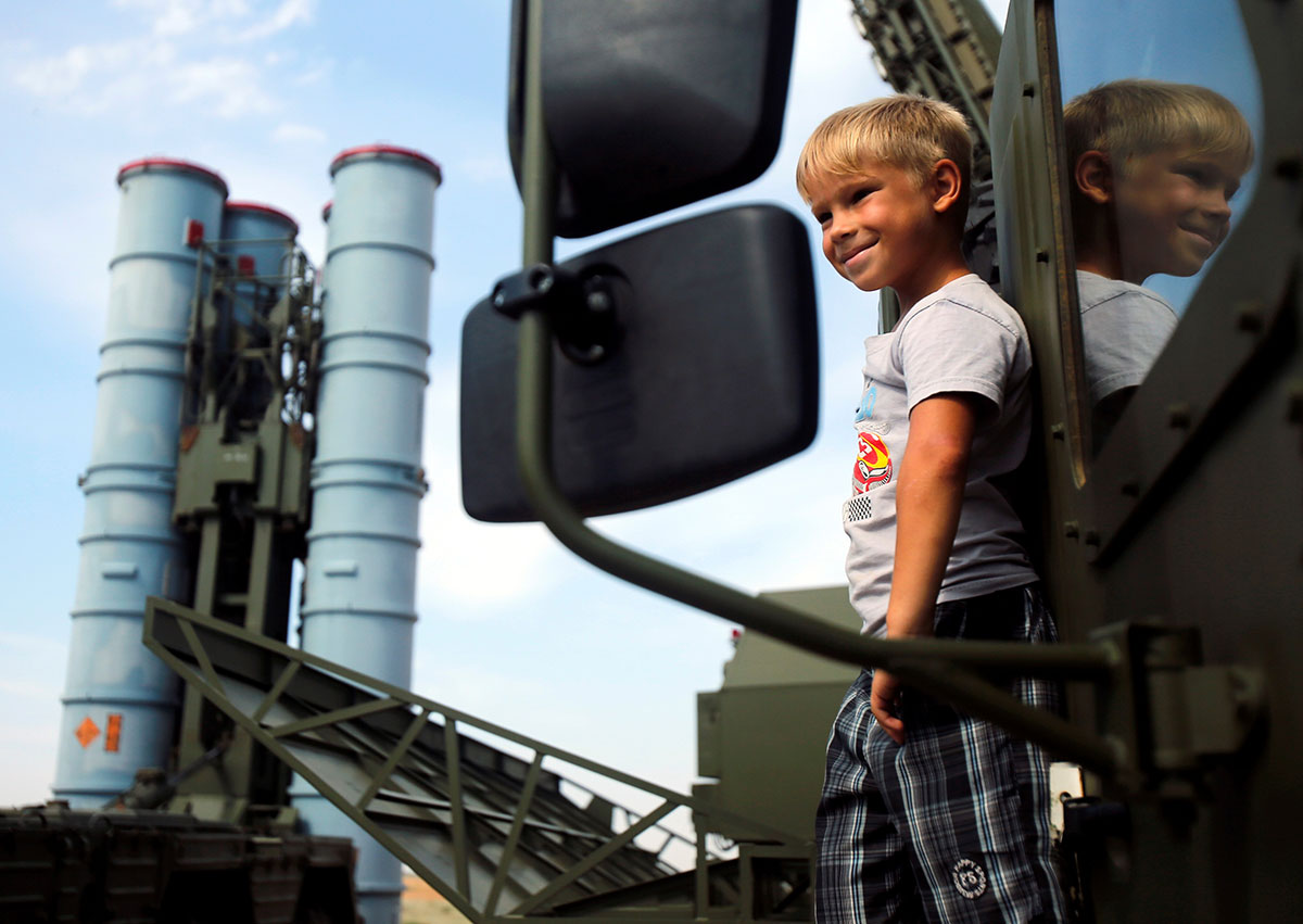A boy stands on the S-300 air defence mobile missile system during the International Army Games 2016 at the Ashuluk military polygon outside of Astrakhan, Russia. 