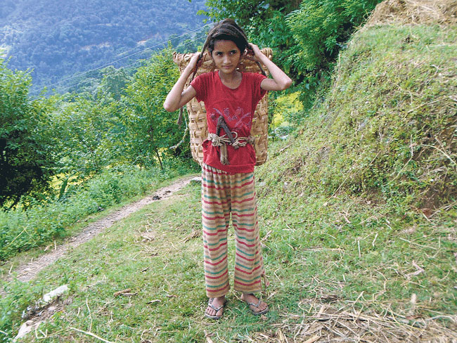 Fourth grader Asmita cuts and carries grass to help her mother during her holidays. (Anita)