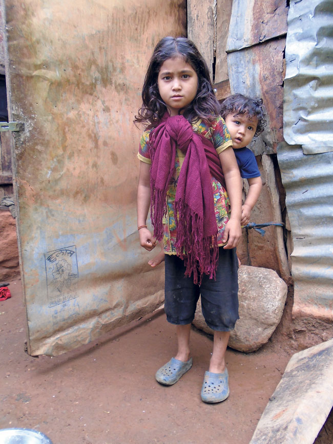 A little girl carries her brother in Mangalsen, Achham. (Asmita)