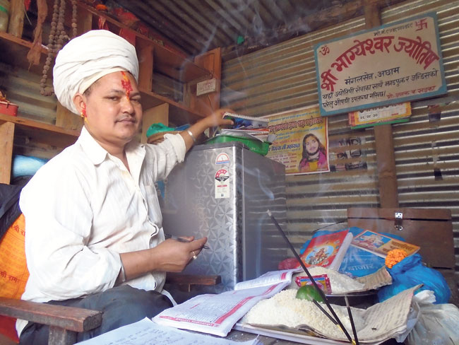 46-year-old Janak Bahadur Khadka, a local religious leader, waits for clients in his shop. (Binita)