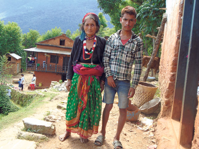 A differently abled mother and son stand outside their home in Mangalsen of Achham. (Neelam)