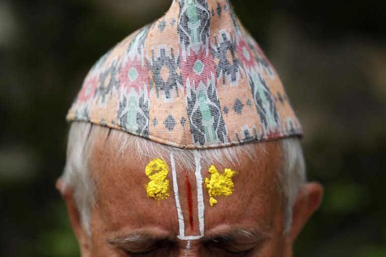 A Nepalese Hindu priest performs rituals during Kuse Aunsi at Gokarneshwar Hindu temple in Kathmandu, Nepal, Thursday, Sept. 1, 2016. Kuse Aunsi is a Hindu festival where fathers, living or dead, are honored. Children with living fathers show their appreciation by giving presents and sweets and those whose fathers are deceased pay tributes at Gokarneshwar temple. (AP Photo/Niranjan Shrestha)