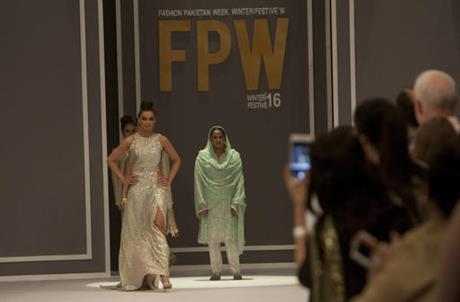 Pakistan's gang rape victim Mukhtar Mai, center right, walks with models during a fashion show in Karachi, Pakistan, Tuesday, Nov. 1, 2016. Gang-raped and paraded naked 14 years ago, Mukhtar Mai walked on a ramp in Pakistan fashion week on Tuesday. A red-carpet reception accorded in Pakistani southern city of Karachi by country's elite fashionista is her debut appearance, which she says she's doing as a symbol of courage for womenfolk. 