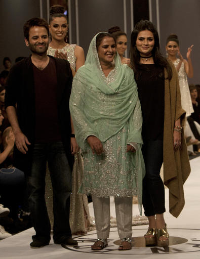 Pakistan's gang rape victim Mukhtar Mai, centre, walks with models during a fashion show in Karachi, Pakistan, Tuesday, Nov. 1, 2016. Gang-raped and paraded naked 14 years ago, Mukhtar Mai walked on a ramp in Pakistan fashion week on Tuesday. A red-carpet reception accorded in Pakistani southern city of Karachi by country's elite fashionista is her debut appearance, which she says she's doing as a symbol of courage for womenfolk. (AP Photo/Shakil Adil)