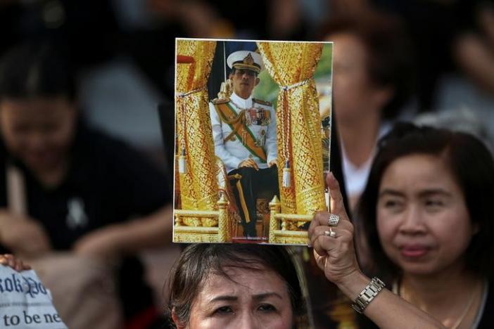 A woman holds up a picture of Thailand's Crown Prince Maha Vajiralongkorn before he arrives at the Grand Palace in Bangkok, Thailand, December 1, 2016. REUTERS/Athit Perawongmetha