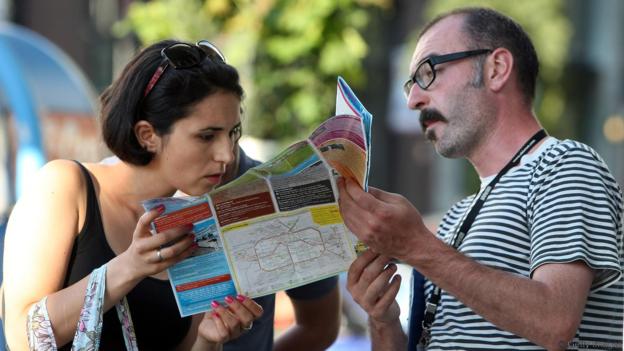  Tourists look at a map of Berlin on August 15, 2012 in Berlin, Germany. In 2010, nine million tourists visited the German capital, and ten million came in 2011, a new record. Tourism, a major industry for the city since the fall of the Berlin Wall, contributes 9 billion euros (USD 11.1 billion) into the local economy annually, and has a high employment impact, with 230,000 Berliners earning a living in the tourism sector. The increase in visitors is not limited to Berlin; 75 out of 80 German cities reported more tourists in 2011 over the previous year.  (Photo by Adam Berry/Getty Images)